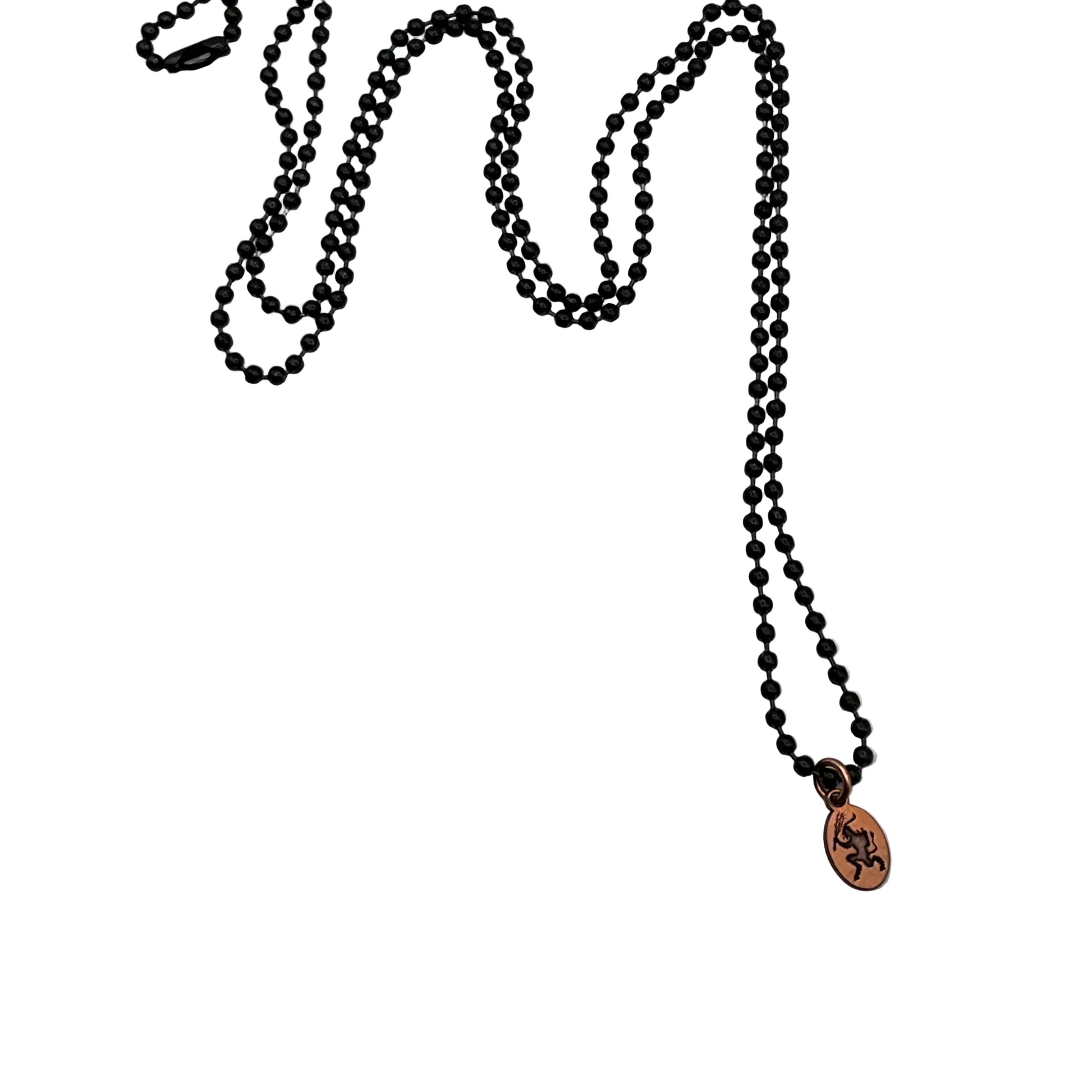 Black ball chain necklace with a copper Krampus pendant on a white background