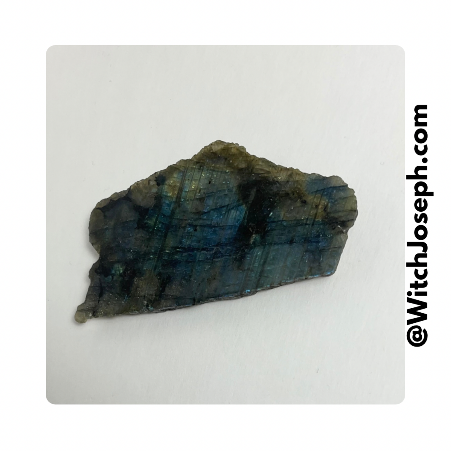 Blue and green Labradorite specimen on a white background with 'WitchJoseph.com' text.