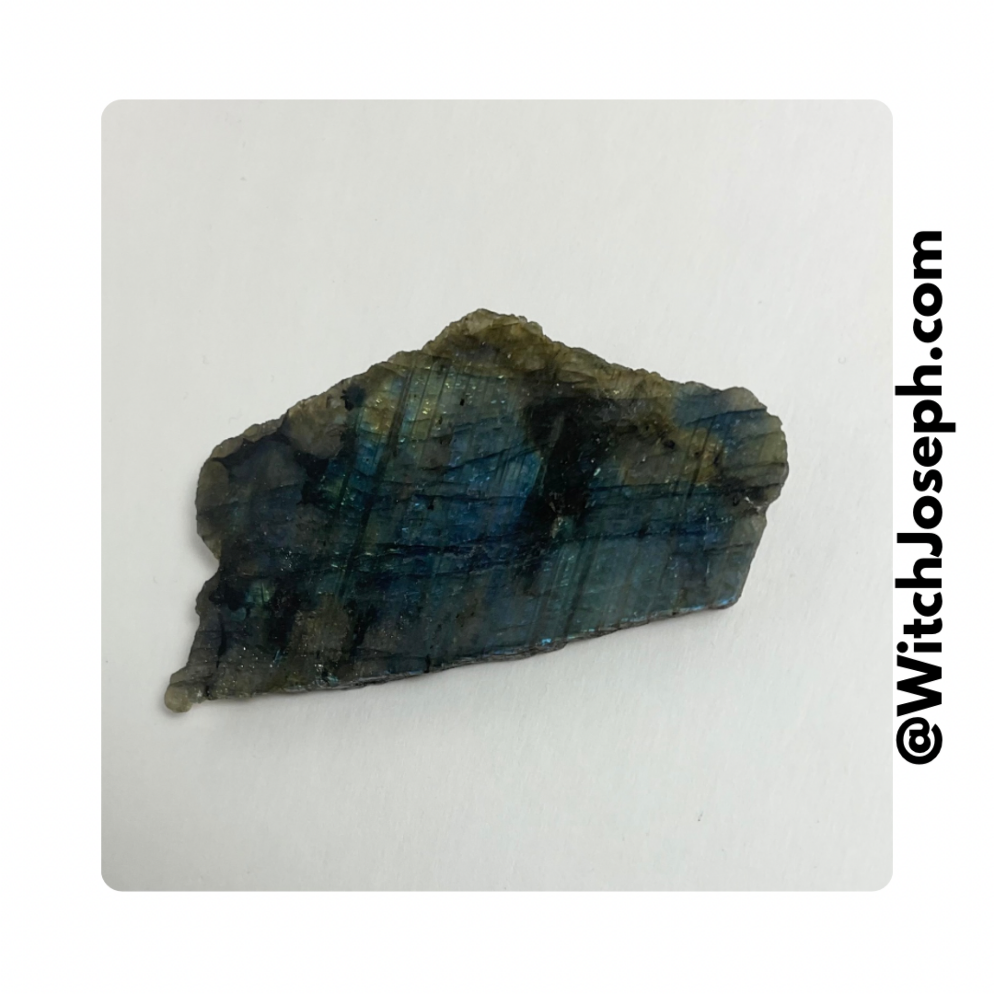 Blue and green Labradorite specimen on a white background with 'WitchJoseph.com' text.