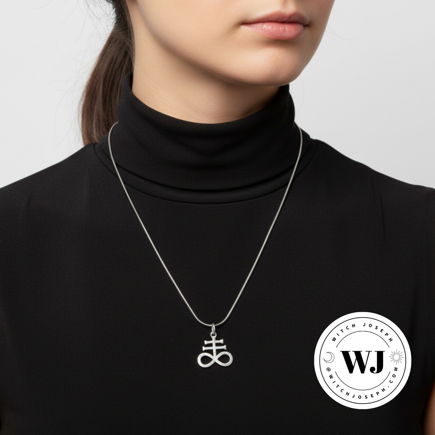Person wearing a black turtleneck with a silver Leviathan Cross necklace showing the Witch Joseph logo in the lower right hand corner