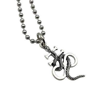 Silver tone Leviathan Cross necklace with a serpent on it, on a white background.