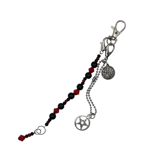 Purse Charm with red and black beads and crystals and a pentagram charm and a Lilith seal charm on a white background