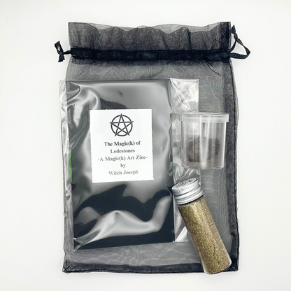 The Lodestone Kit from Witch Joseph showing the contents laid out on their black organza bag…a Lodestone, a Witch Joseph Lodestone Zine and a vial of gold magnetic sand against a white background.