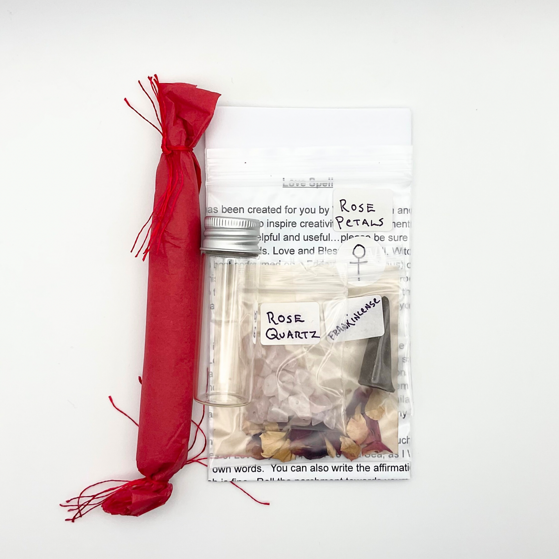 Packaged rose quartz crystals with candle and love spell ingredients on a white background