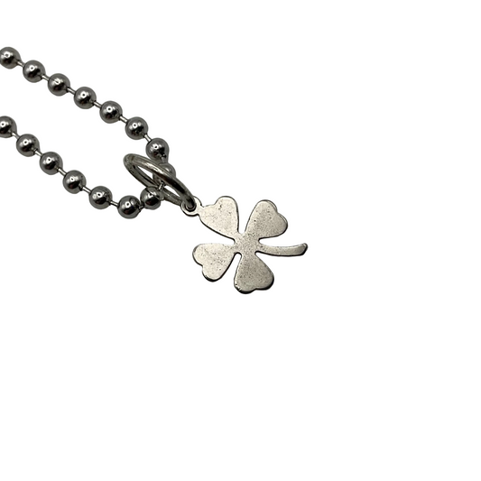 Silver tone four-leaf clover pendant on a ball chain against a white background