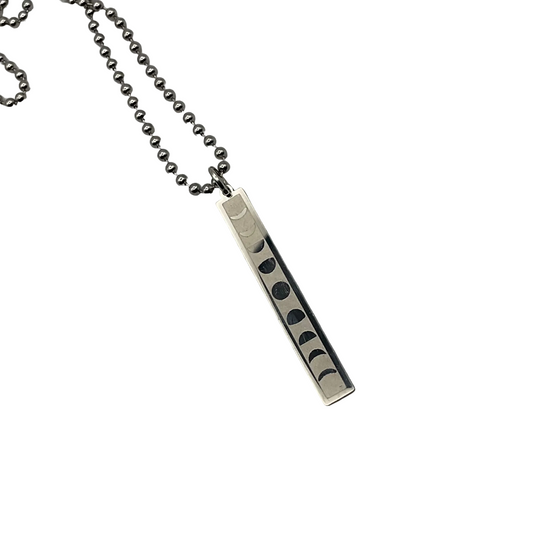 Silver necklace with a steel bar pendant featuring moon phases on a white background