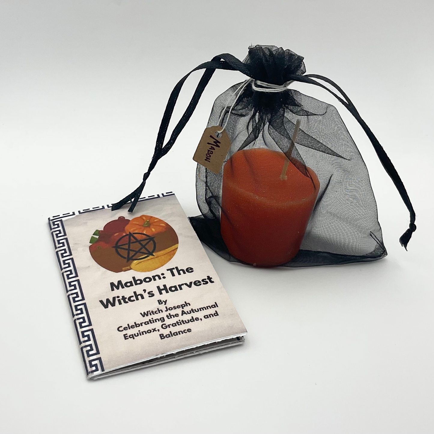 Zine titled 'Mabon: The Witch's Harvest' with a candle in a sheer black bag on a white background