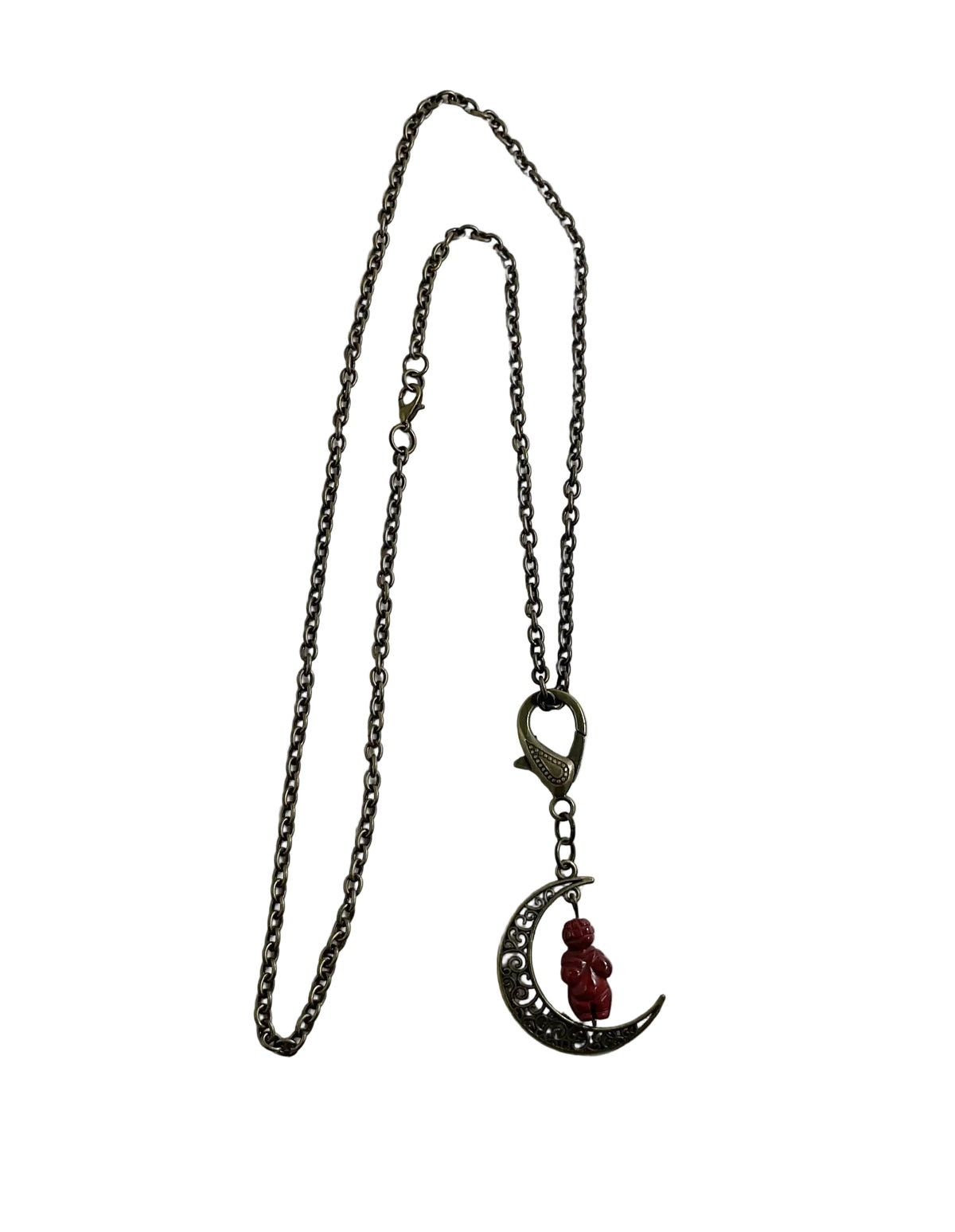 A gothic-style pendant necklace featuring a dark metal chain, a lobster shaped clasp, and a crescent moon pendant with a small red jasper Goddess bead accent, displayed on a plain white background.