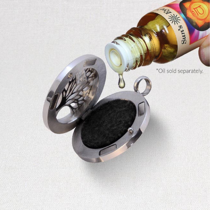 Moon Locket Aromatherapy from Suns Eye shown being loaded with a fragrance oil against a white background.