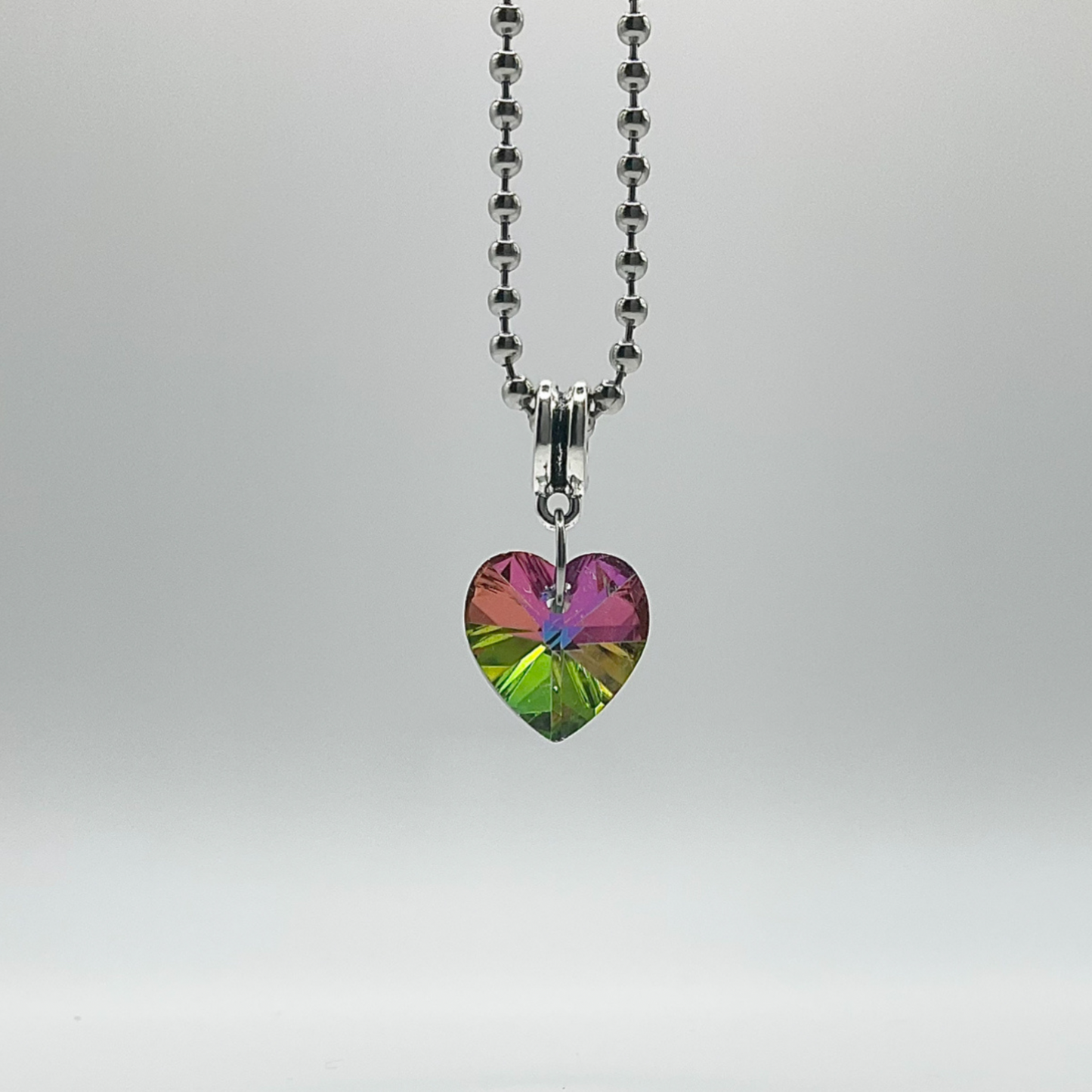 Ball chain charm Necklace with a heart-shaped, multicolored crystal pendant on a white background