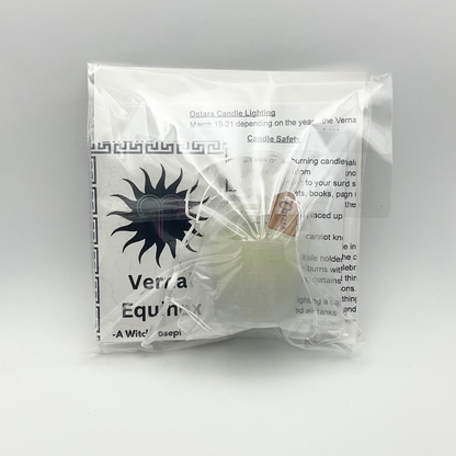 The Ostara Kit packaged and displayed from the back showing the Ostara Candle and zine and other contents against a white background.