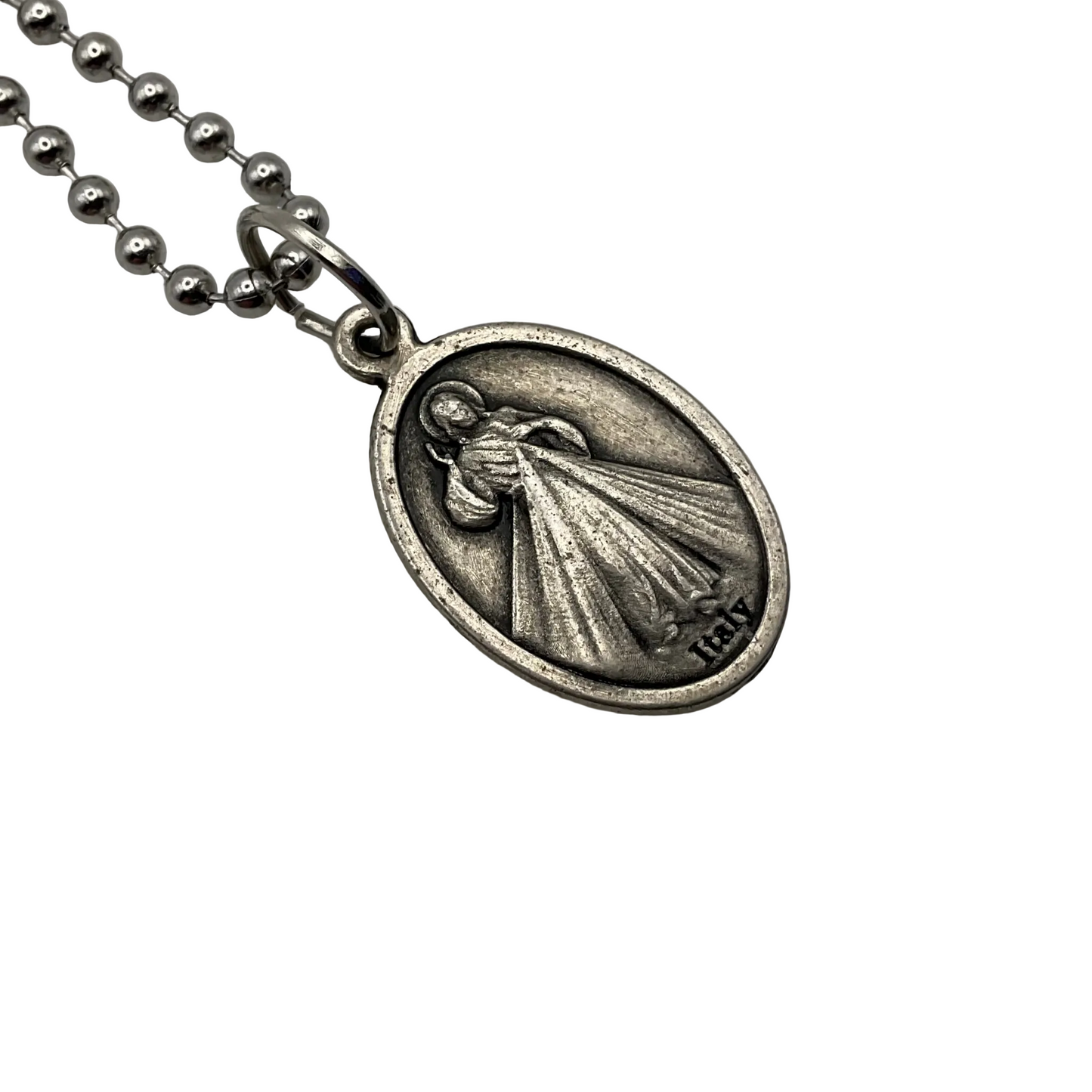 Silver tone pendant necklace with an engraved design of the Divine Mercy, shown in this photo, and an image of Our Lady of Guadalupe on the reverse… on a ball chain displayed against a white background