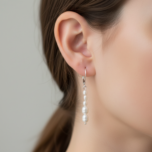 Freshwater Pearl dangle sterling earring worn by a person with a neutral background