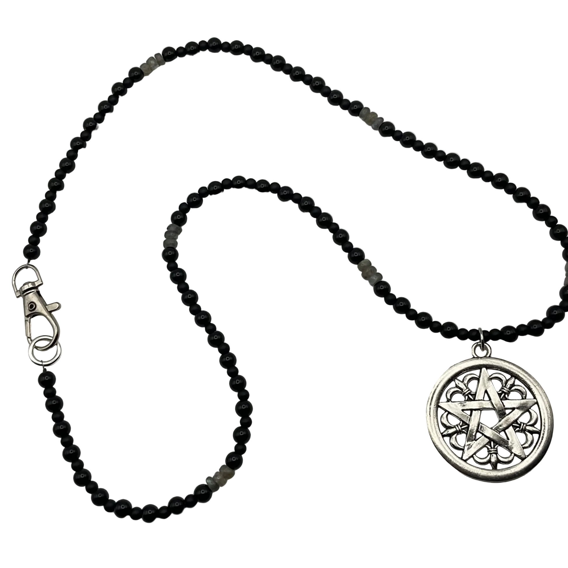 Black beaded necklace with a silver pentacle with fleur de lis design pendant on a light white background