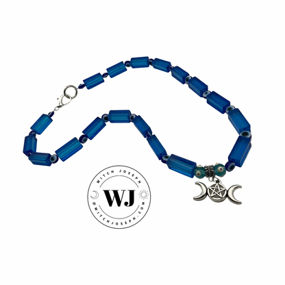 Blue beaded necklace with a silver triple Goddess pendant on a white background, featuring the brand 'Witch Joseph'.