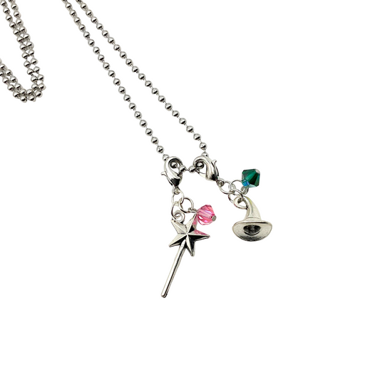 Necklace with charms including magic wand with a pink crystal bead and a witch hat with a green crystal bead on a white background