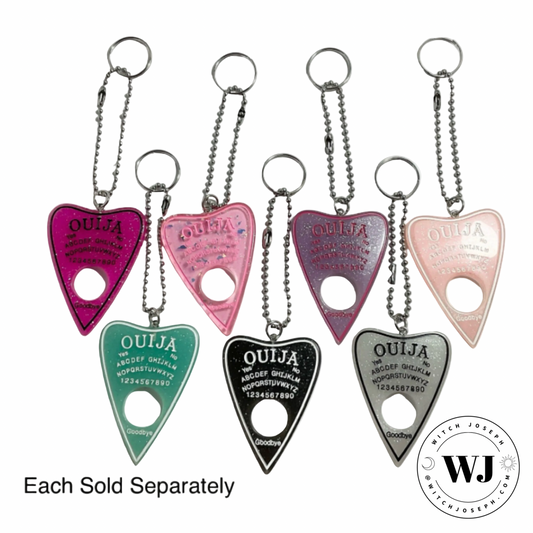 Set of colorful Ouija board planchette keychains displayed with WJ branding on a white background…each sold separately