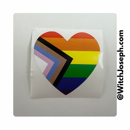 Heart-shaped sticker with rainbow progress pride design on a white background