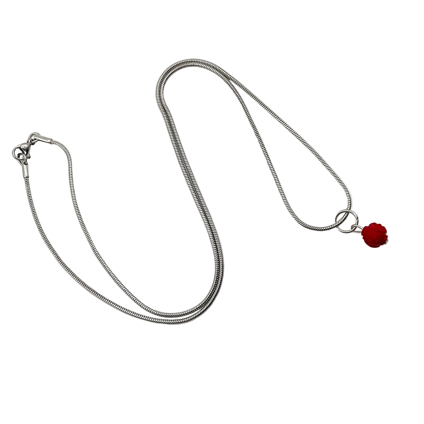 Silver tone necklace with a red coral pendant on a white background