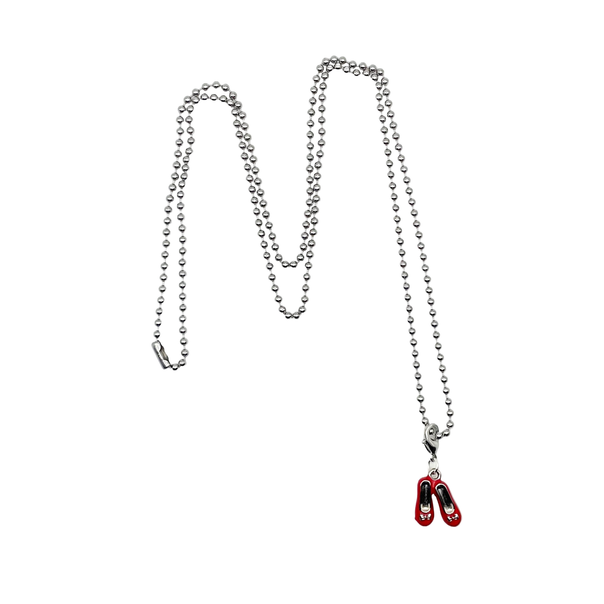 Metallic necklace with a small red shoes pendant on a white background