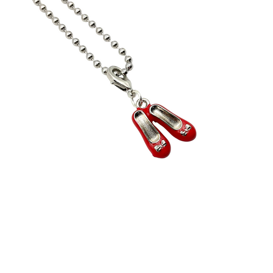 Red shoes charm on a silver tone chain against a white background