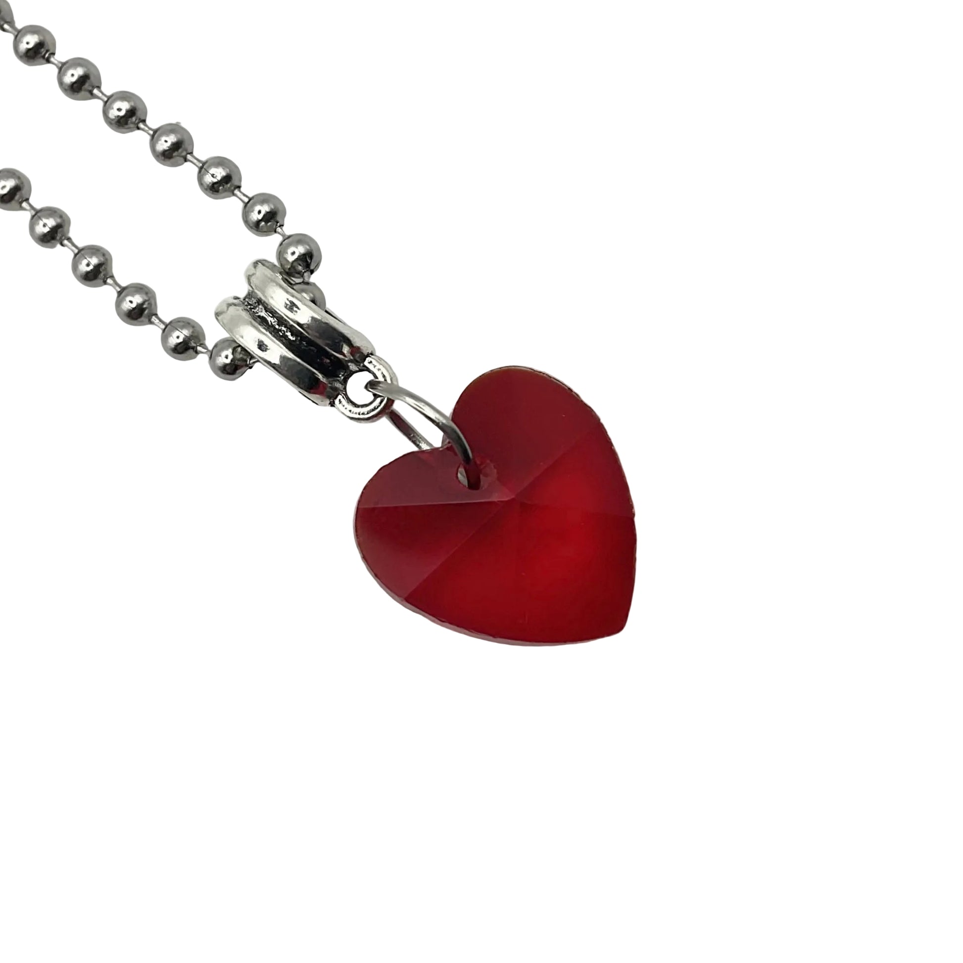 Red heart-shaped crystal pendant on a silver tone ball chain against a white background