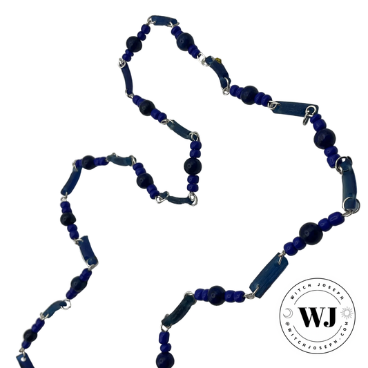 Blue beaded station necklace with silver tone jump rings and ancient Roman glass beads with Lapis and blue seed beads displayed on a white background with the Witch Joseph logo