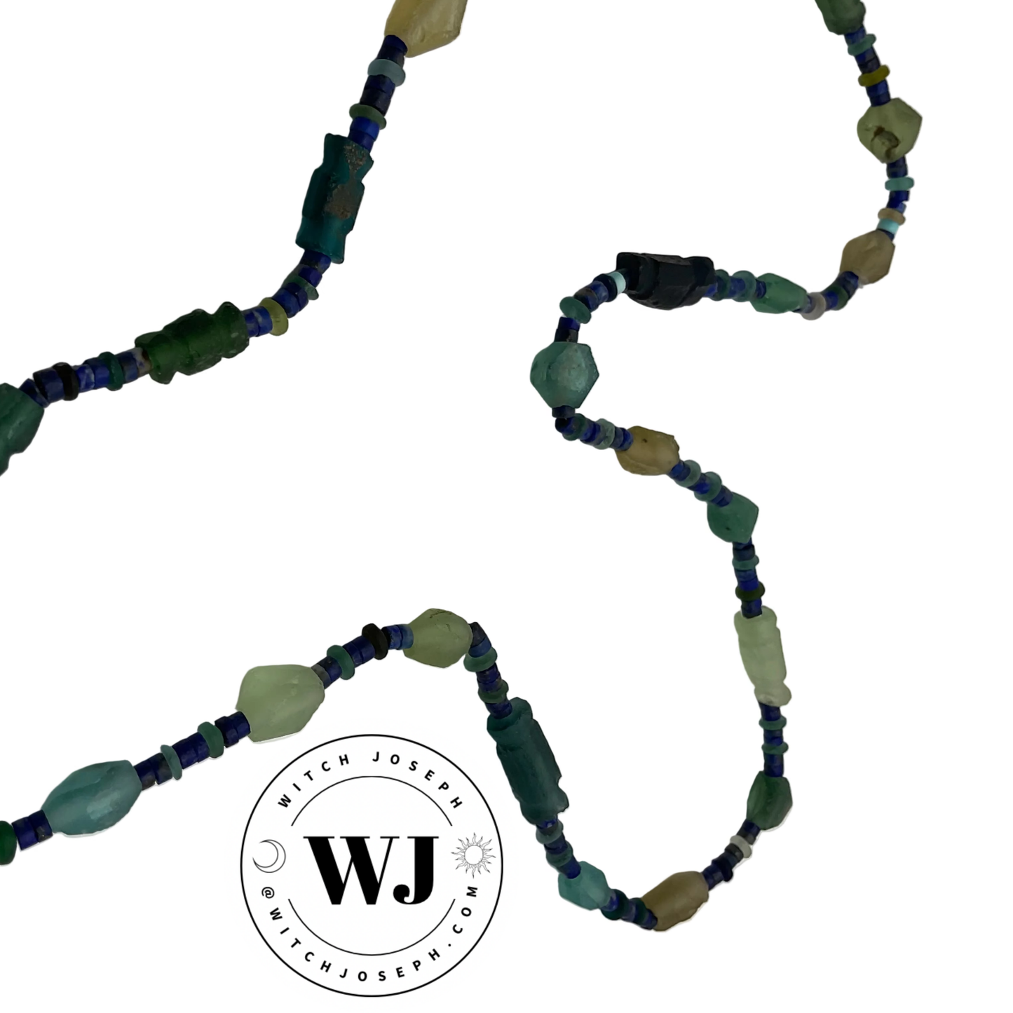 Beaded necklace with green and blue Roman glass beads and lapis lazuli displayed on a white background, featuring the Witch Joseph logo.