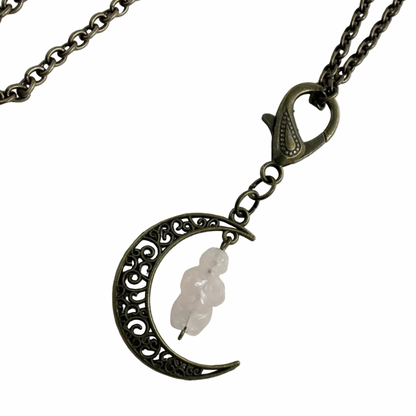 Bronze tone Necklace with a crescent moon pendant with rose quartz goddess figure on a white background