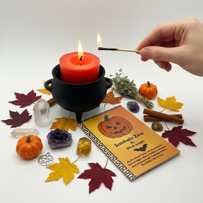 The Witch Joseph Samhain Candle Kit being used…the candle placed and being lit in a cauldron and the Samhain Zine in front.  Halloween leaves and items around the candle.