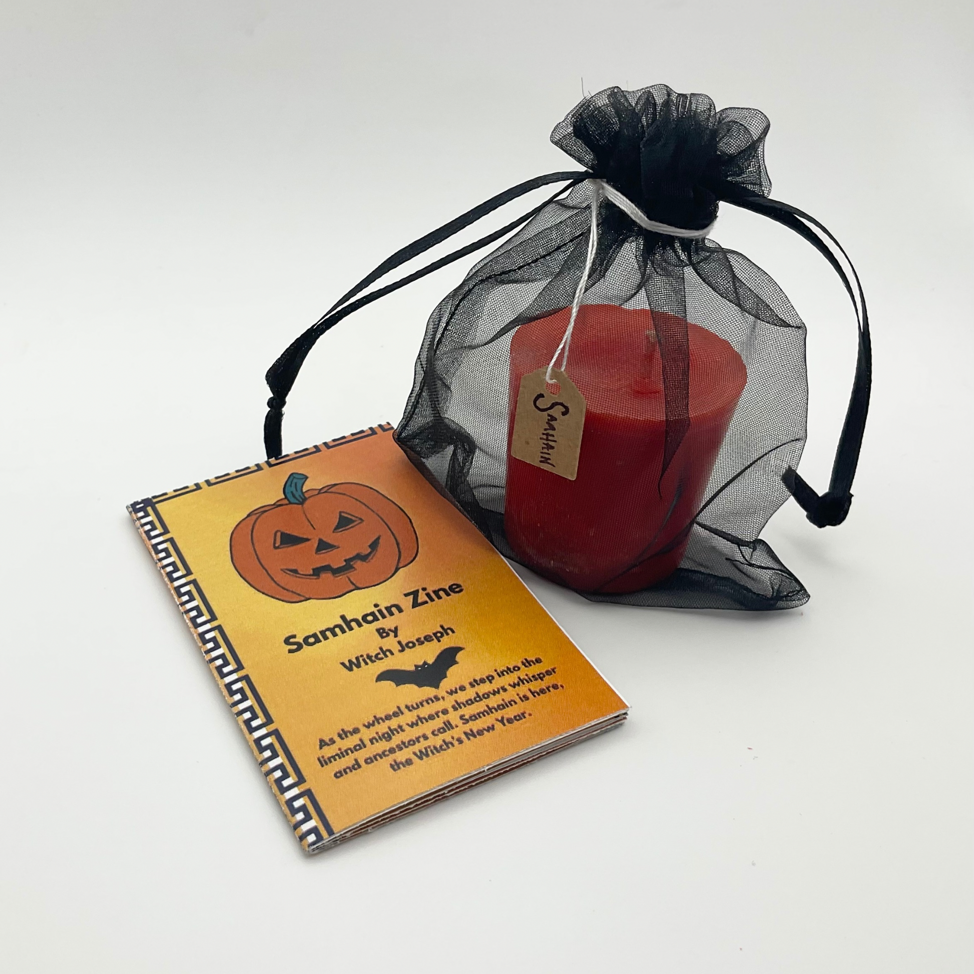 Halloween-themed Witch Joseph zine and orange candle in a black sheer bag on a white background