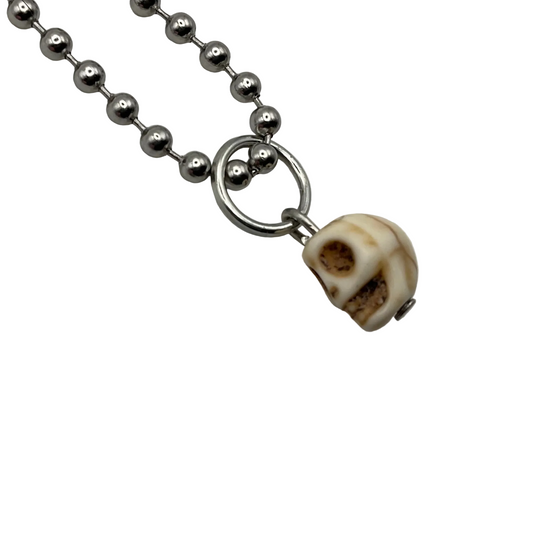 Charm Necklace with a skull-shaped droplet pendant on a white background