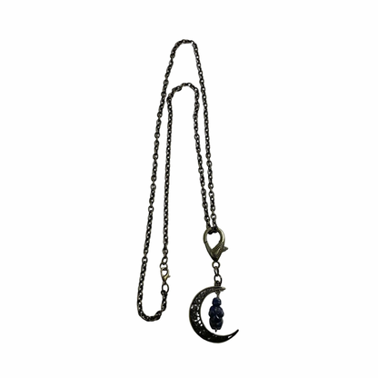 Bronze tone Necklace with a crescent moon pendant with a sodalite goddess bead displayed on a white background