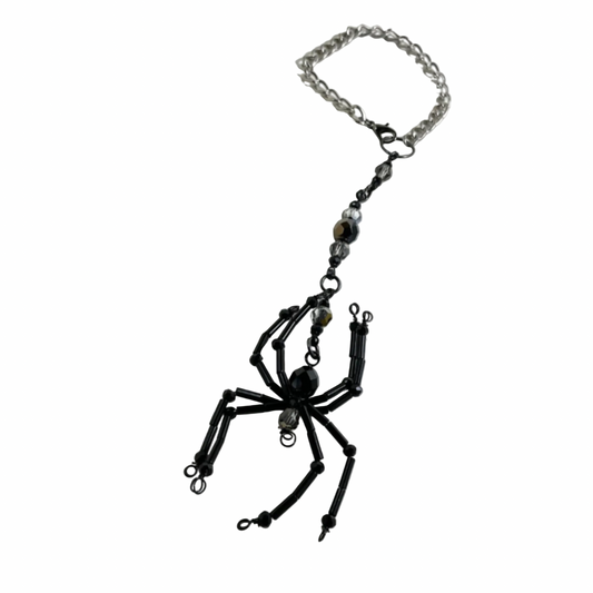 Black spider-shaped Sun Catcher with iridescent accent beads on a chain against a white background