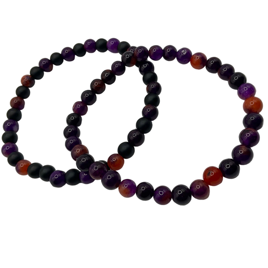Two beaded bracelets with purple, black, and orange beads on a white background