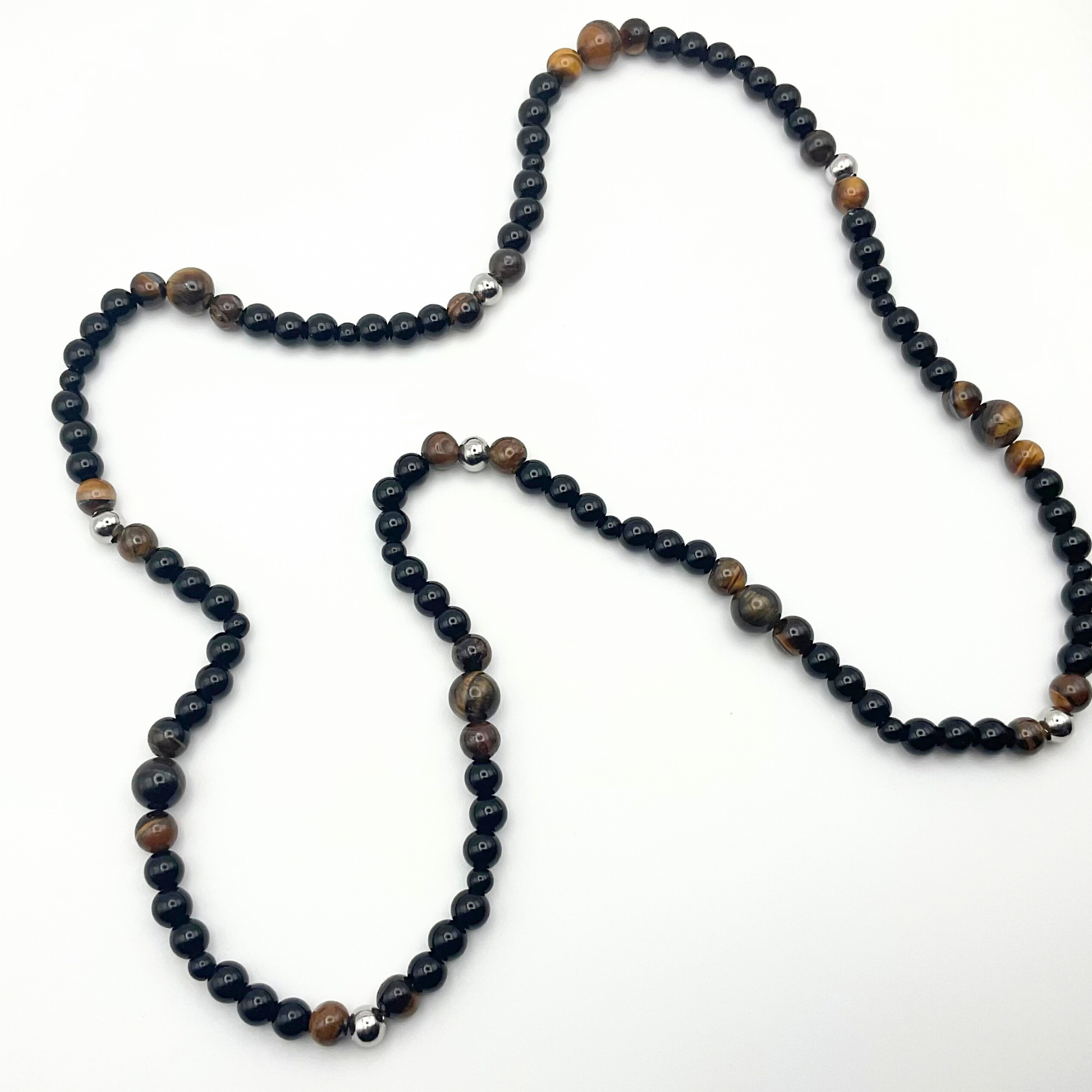 Brown Tigers Eye beaded necklace with black and steel bead accents on a white background.