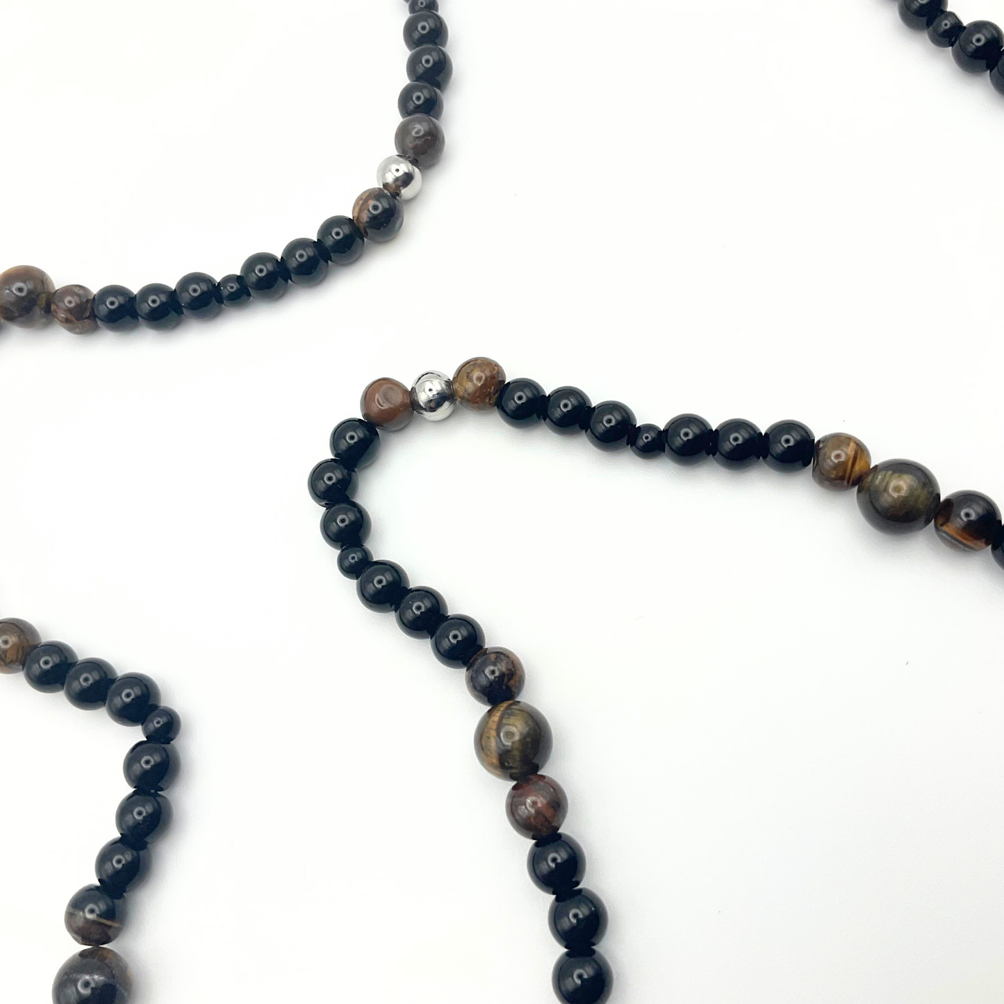 Brown Tigers Eye Necklace with black and steel bead accents on a white background.