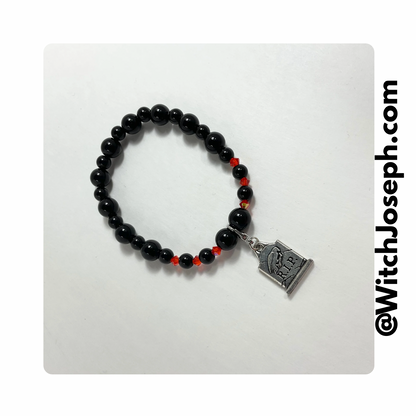 Halloween tombstone charm bracelet with orange and black beads displayed against a light background with the Witch Joseph url.