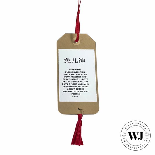 Brown tag with prayer to Tuer Shen for Blessings and global Gay Equality with red tassel on a white background