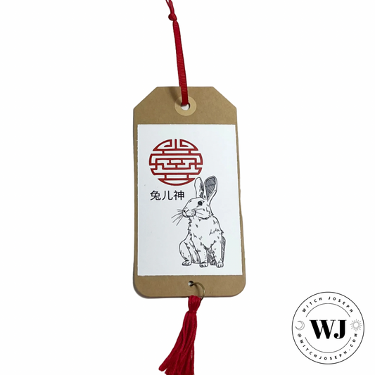Tuer Shen Tag with rabbit illustration and red tassel on a white background