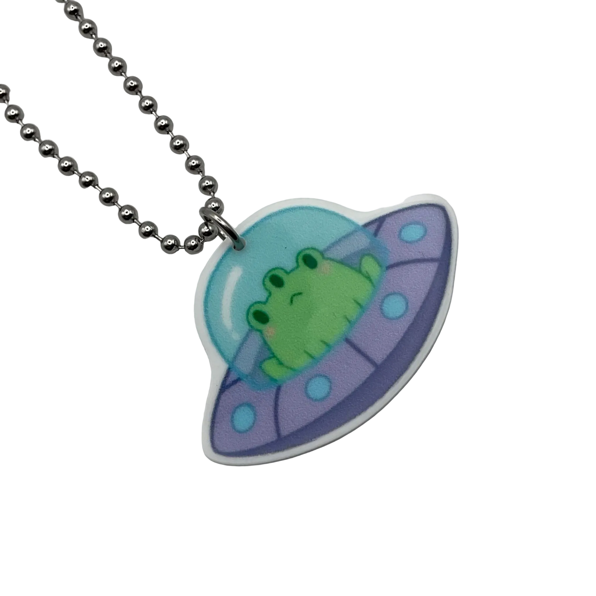 Neon green and alien frog in a purple UFO acrylic pendant on a silver ball chain against a white background