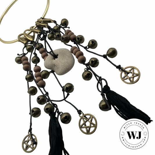 Decorative Door Charm beads, tassels, pentacles charms and a Holey stone displayed on a white background with the Witch Joseph logo.