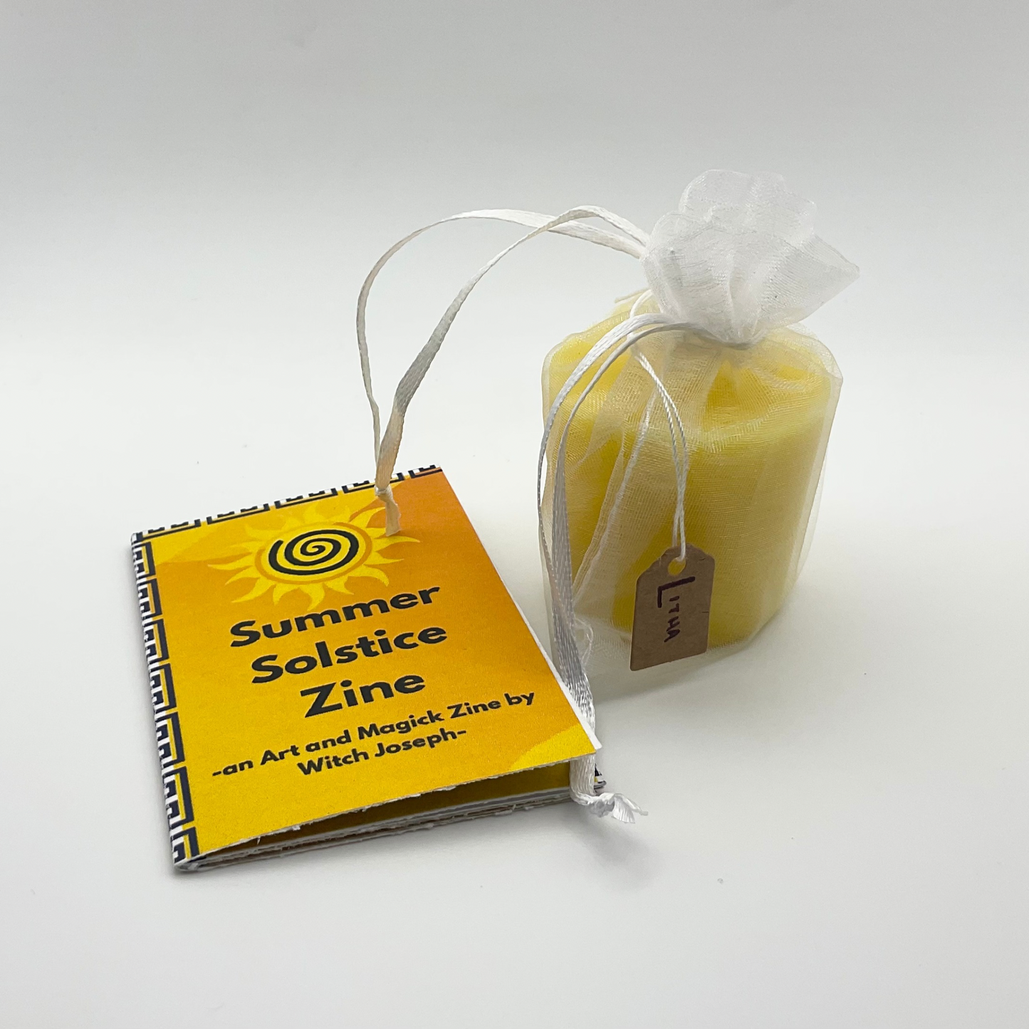 Summer Solstice Zine and candle against a white background