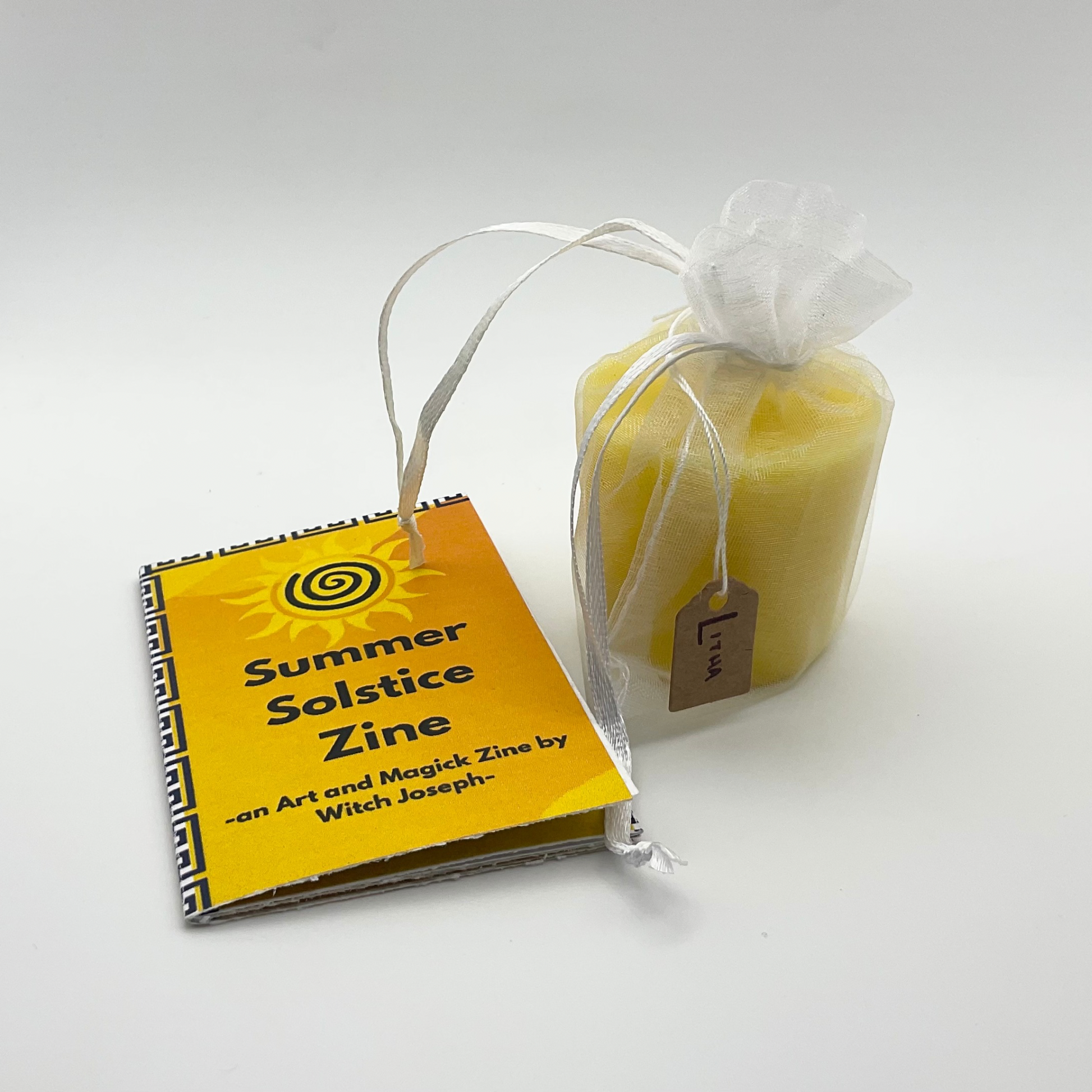 Summer Solstice Zine and candle against a white background