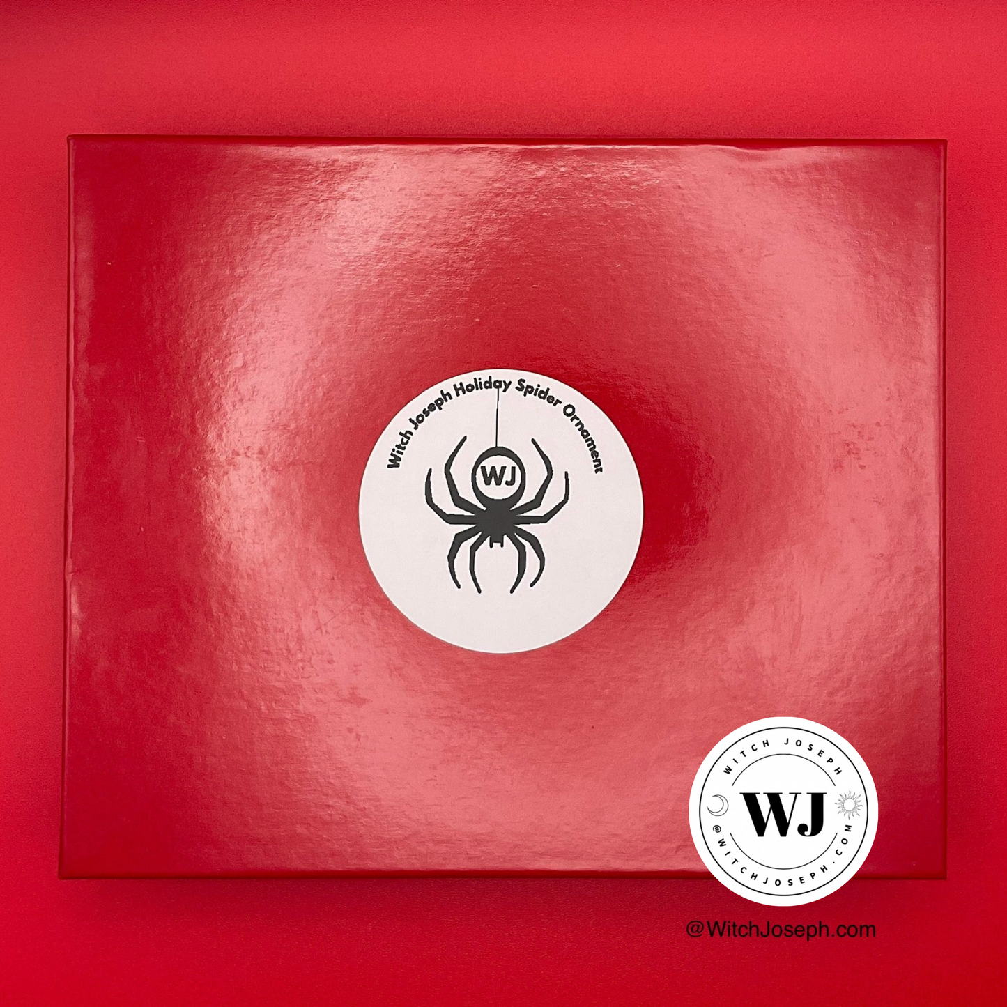 Top of the red spider ornament box showing the lid displayed against a red background with the Witch Joseph logo