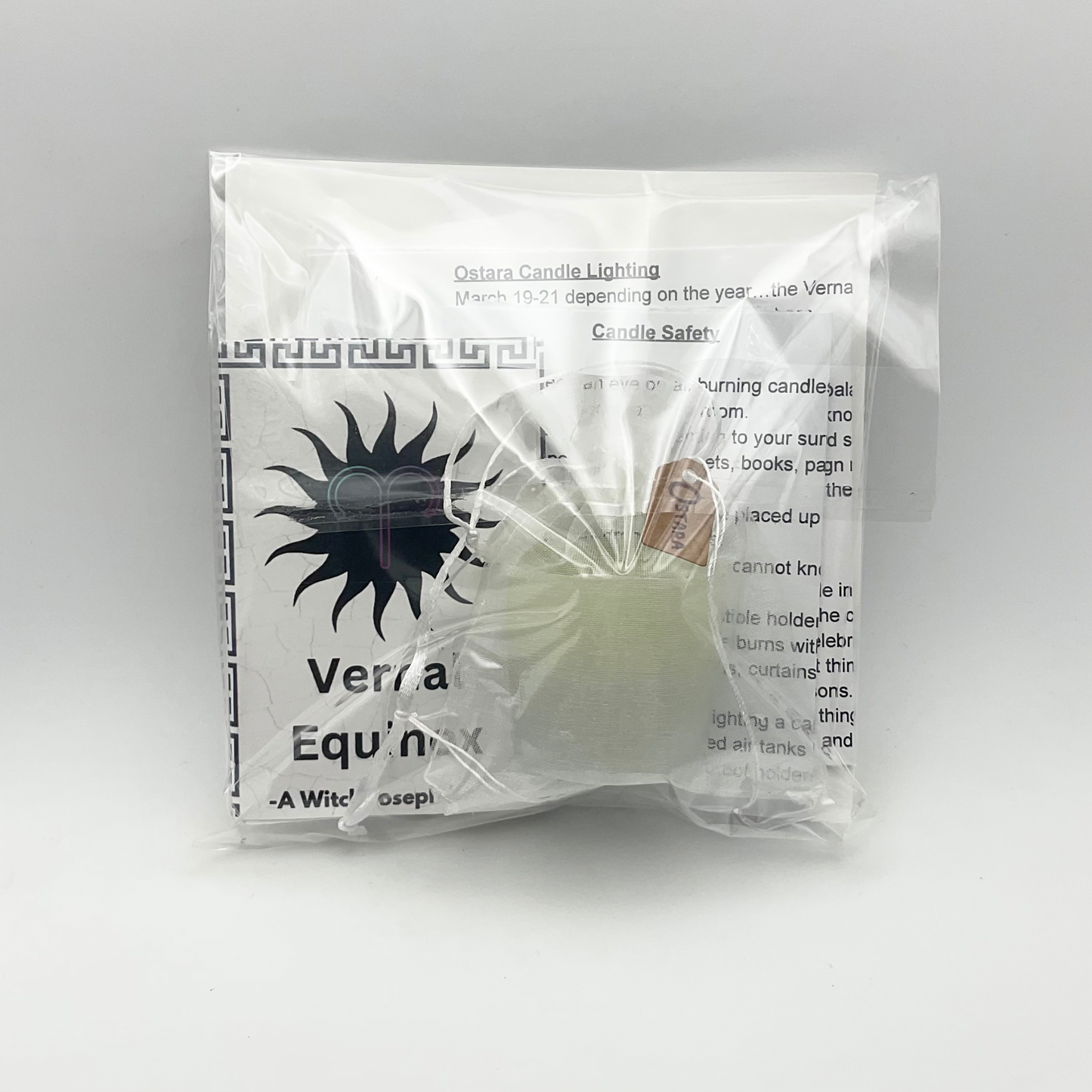 Candle and other contents in a clear packaging with Verna Equinox branding on a gray background