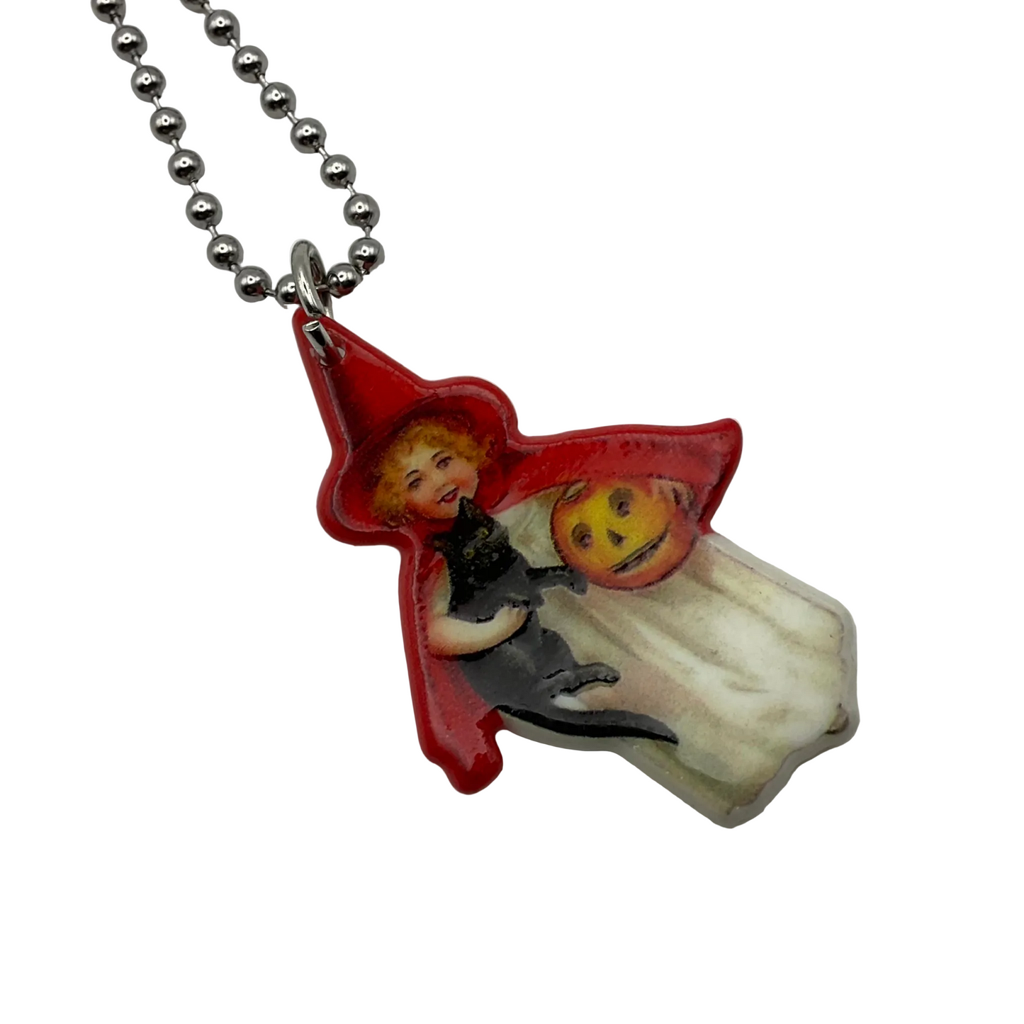 Pendant with a Vintage design of a child trick or treater  in a red hood holding a black cat and a jack o lantern pail for trick or treating on a ball chain displayed on a white background