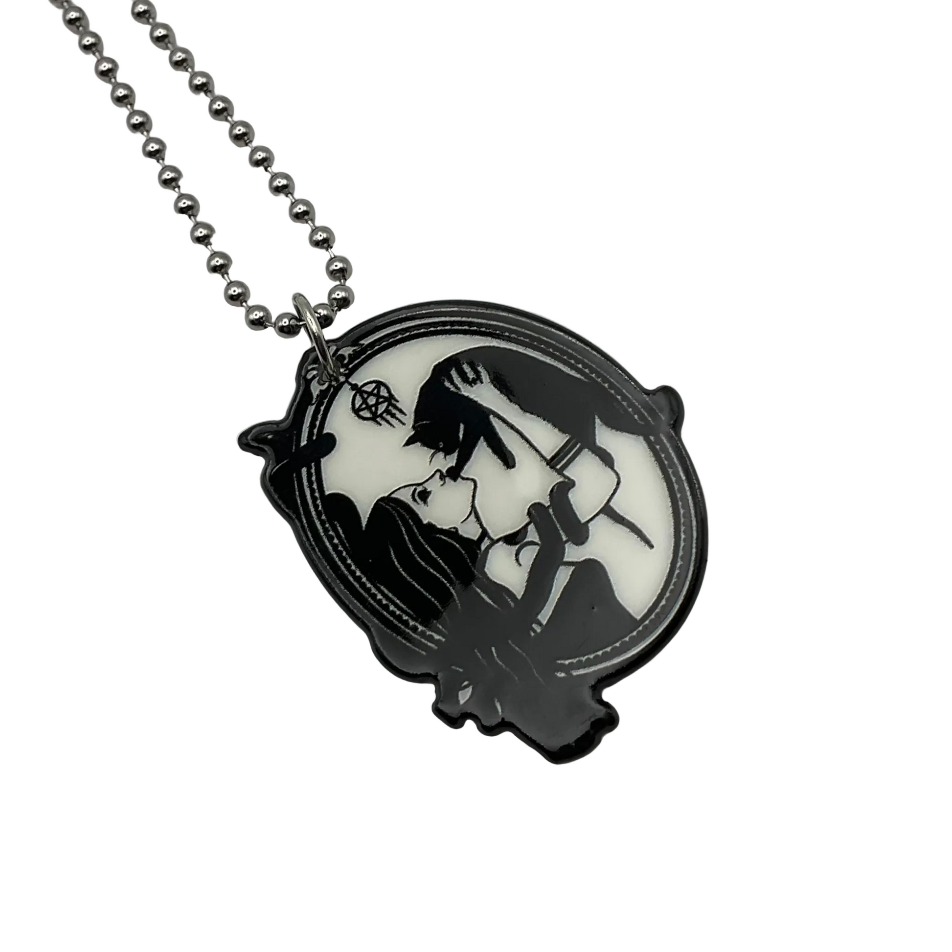 Necklace with a pendant featuring a Witch and black cat design…also with snake on a white background