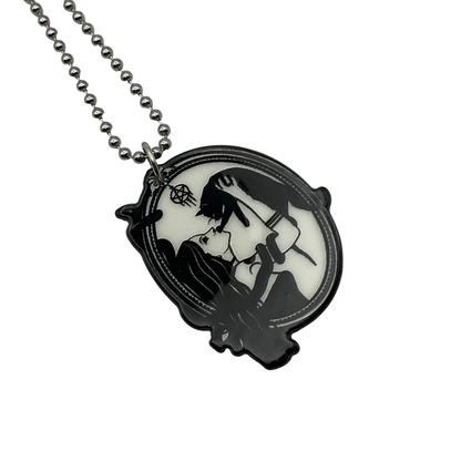 Necklace with a pendant featuring a Witch and black cat design…also with snake on a white background