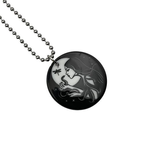 Ball chain Necklace with a circular pendant featuring an artistic design of a Witch and her snake ally on a white background